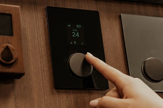 person adjusting smart thermostat